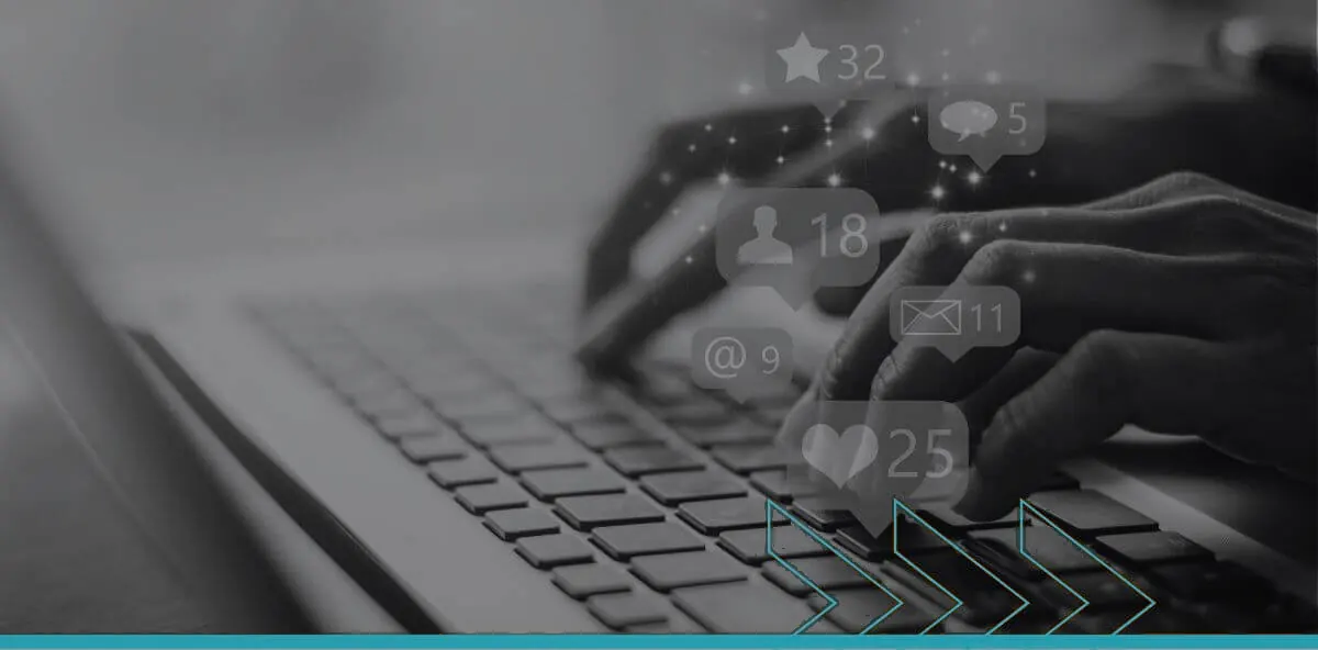 Hands typing on a laptop as social media likes, comments and message notifications appear